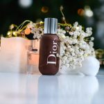 brown dior bottle beside flowers